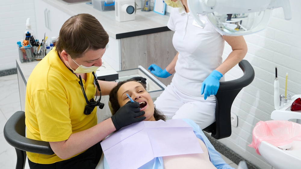 Pregnant woman receiving dental treatment and getting cavities filled while pregnant, showing safe dental care during pregnancy
